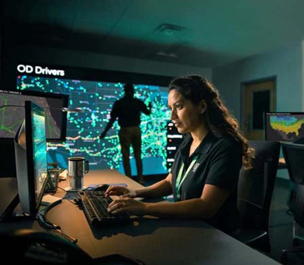 ODFL employee monitoring freight logistics data in a control center with real-time driver tracking.